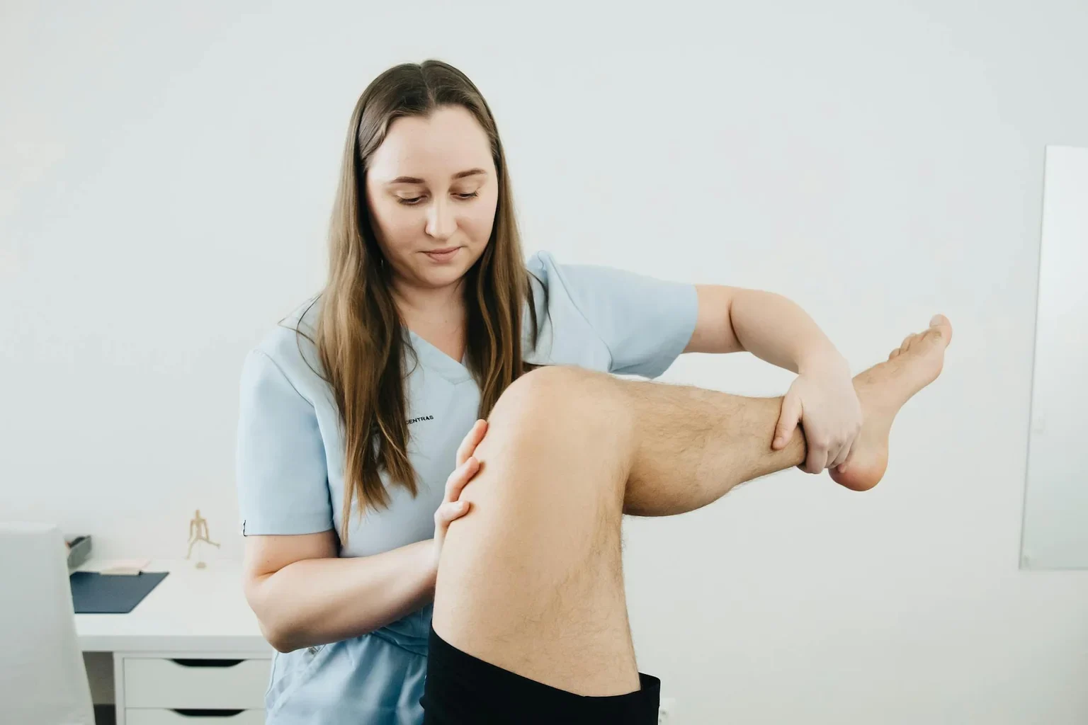 Physical therapist assisting patient with knee rehabilitation exercises
