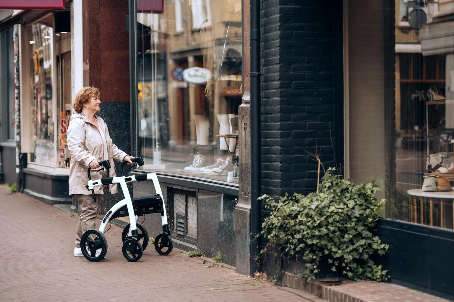 Senior using a walker outdoors during knee replacement recovery