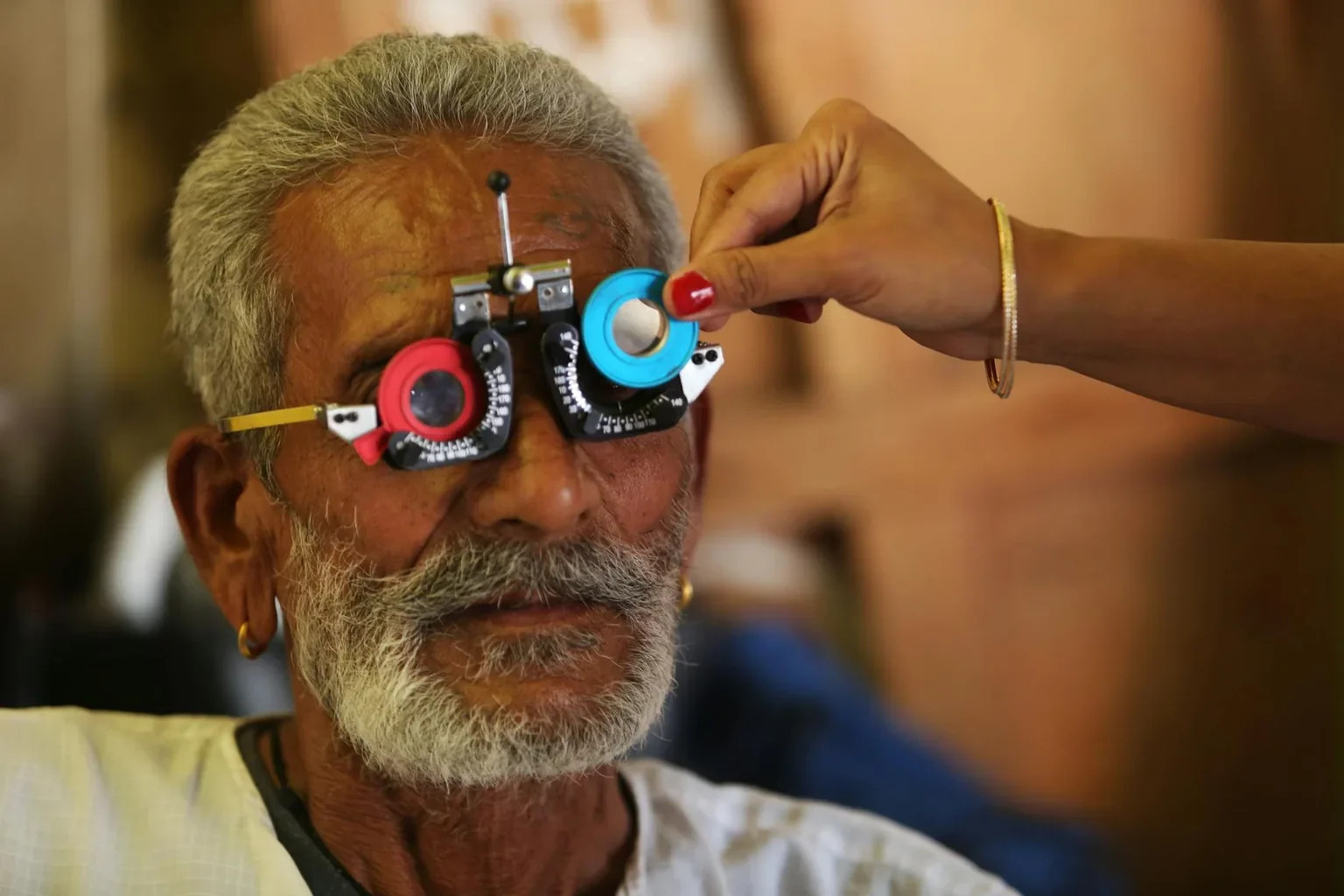 Senior man having a vision test with a trial lens set during an eye examination.