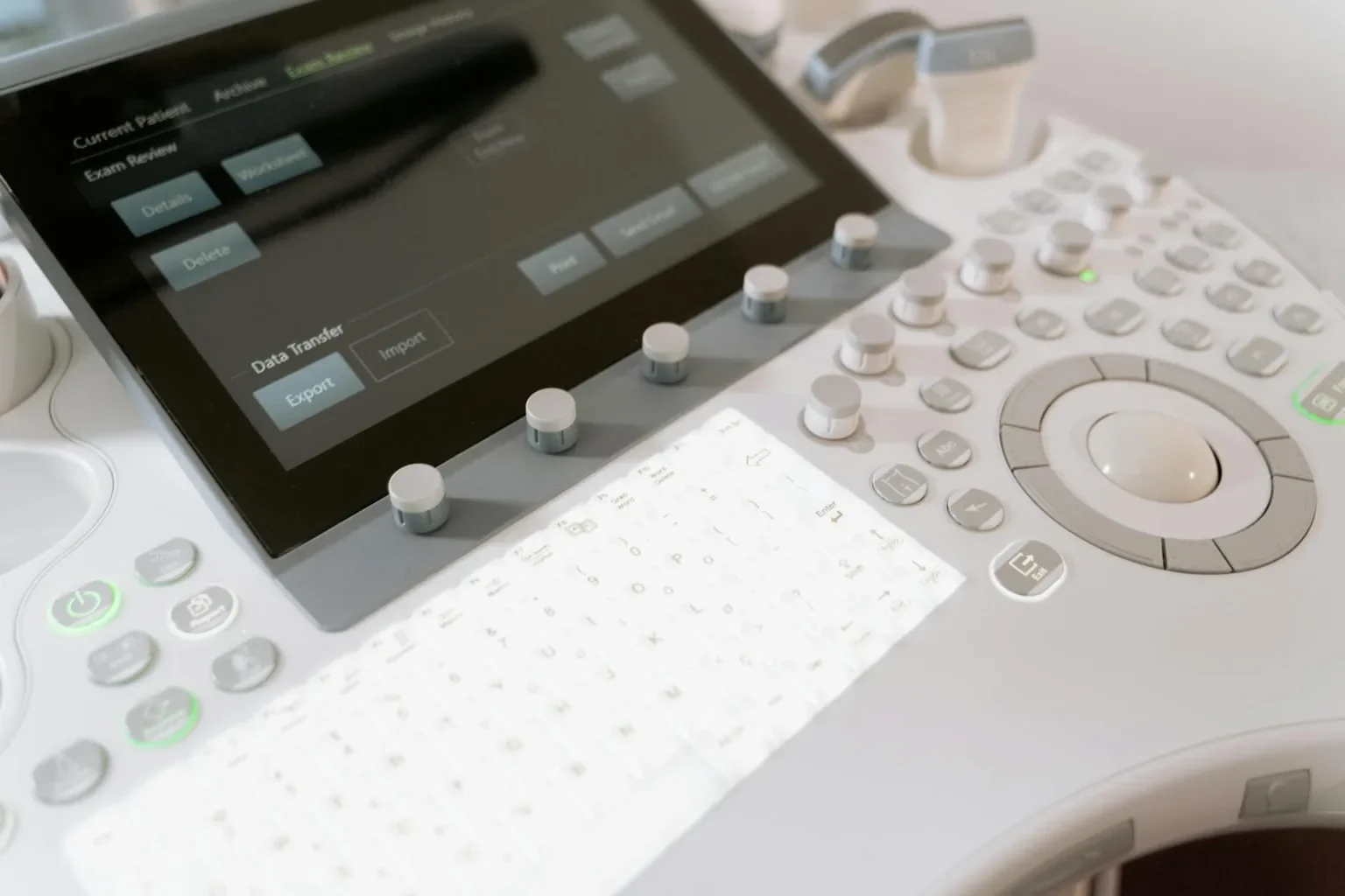 Detailed view of a medical ultrasound machine control panel with buttons and screen.